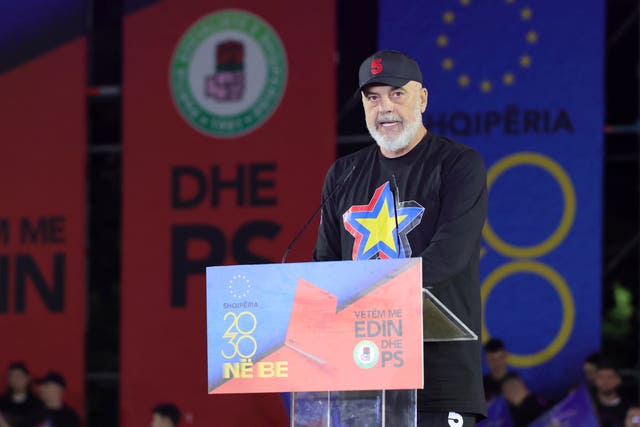 Edi Rama speaks from a podium, wearing a 'No 5' baseball cap