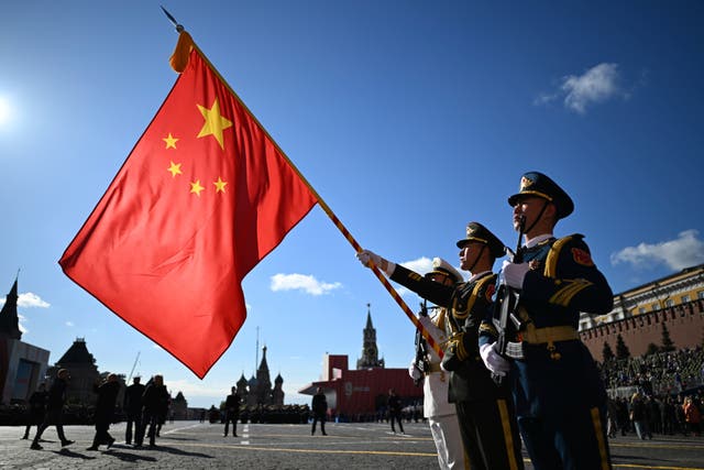 Chinese servicemen hold their national flag as they attend the parade