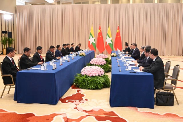 The delegation at two tables before their national flags