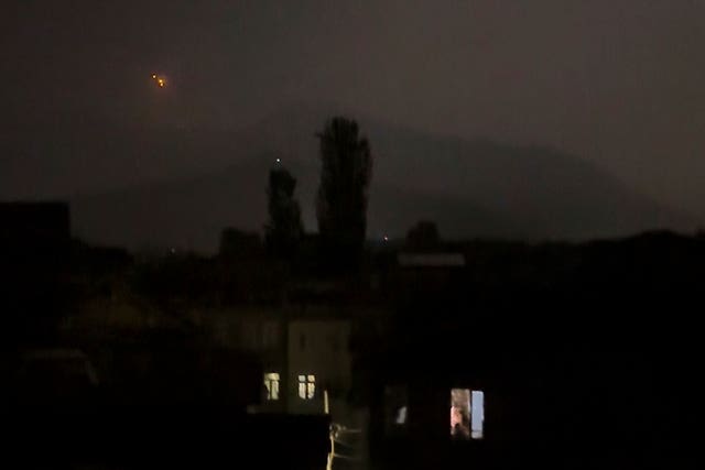 A red projectile is seen in the sky above a residential area