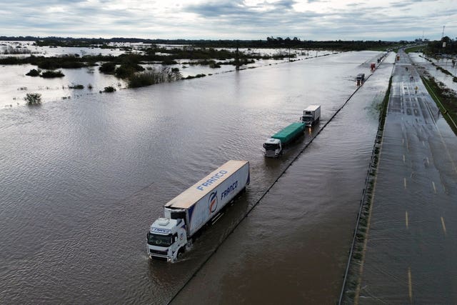 Lorries drive on a flooded highway