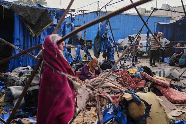 Palestinian people amid the wreckage in their homes