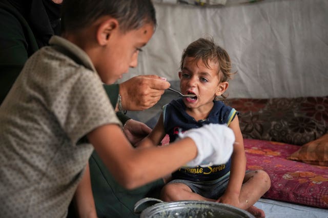 A little boy is fed by his mother