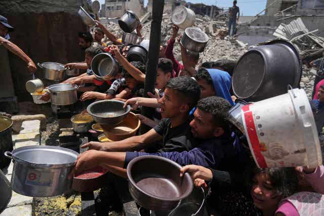 Palestinians struggle to get donated food at a community kitchen in Jabalia, northern Gaza