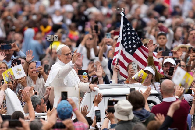 Pope Leo XIV waves as he arrives for his first weekly general audience in St Peter’s Square at the Vatican