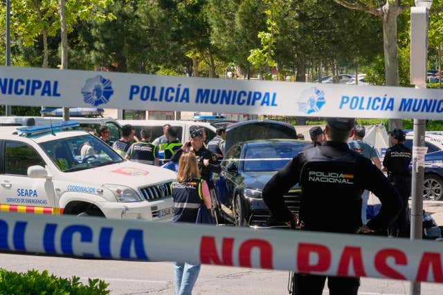 Police officers cordon off the area after an adviser to former Ukrainian president Viktor Yanukovych was shot outside a school in Madrid, Spain
