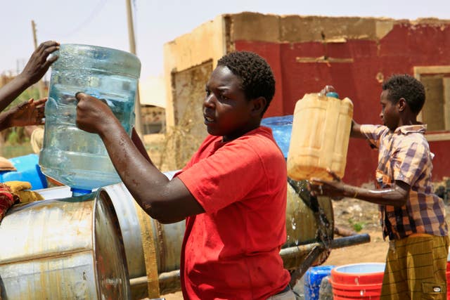 People fill a container with water in Khartoum