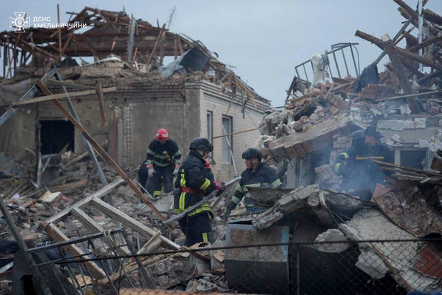 Firefighters working amid the rubble of destroyed buildings