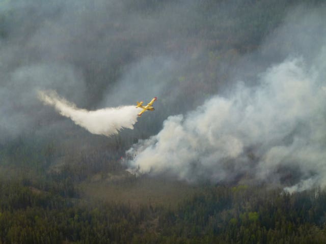 An aircraft drops water on a wildfire in south-east Manitoba