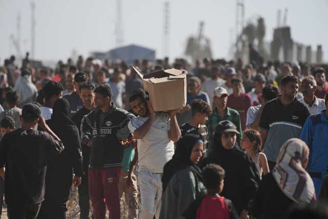 Palestinians carry boxes containing food and humanitarian aid
