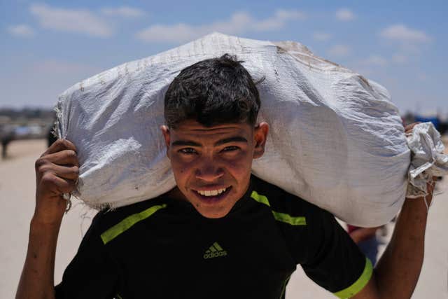 A Palestinian youth carries food and humanitarian aid