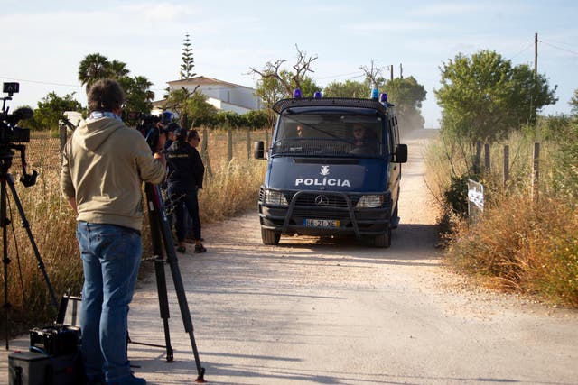 A police van driving down a narrow lane, as a cameraman films it