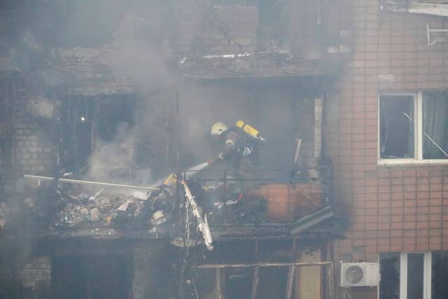 Firefighters tackle a blaze after a Russian attack that hit a residential building in Kharkiv