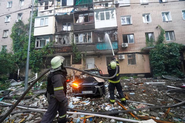 Firefighters tackling a blaze after a Russian attack that hit a residential building in Kharkiv
