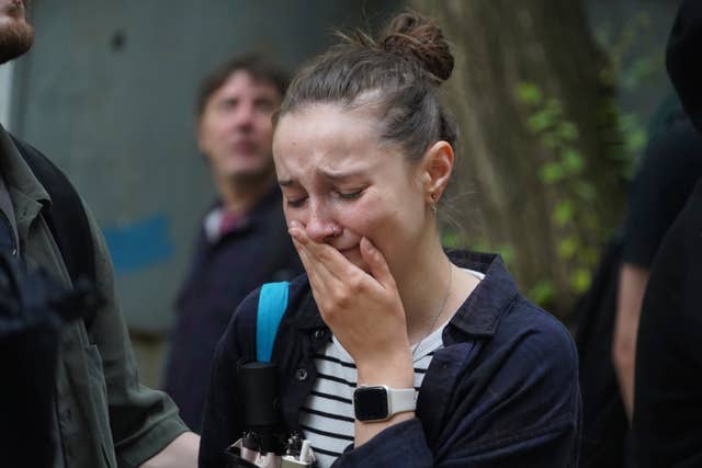 A woman reacts as she looks at the aftermath of a drone and missile attack on a building in Kharkiv, Ukraine