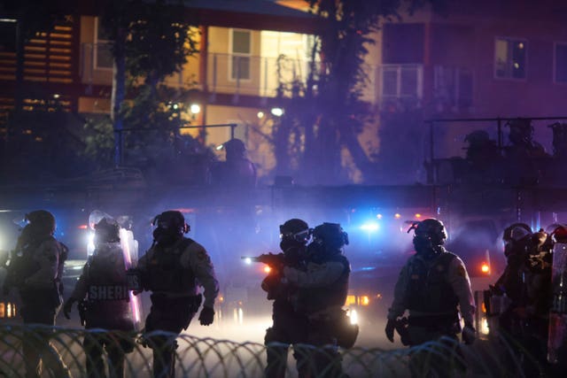 Law enforcement in riot gear walking in a line