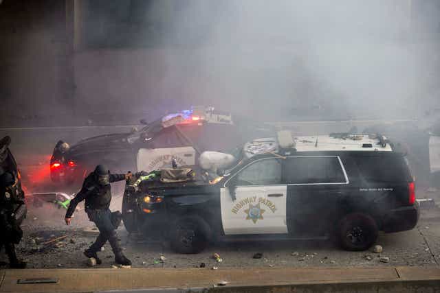 A California Highway Patrol officer pulls an electric scooter off a vehicle