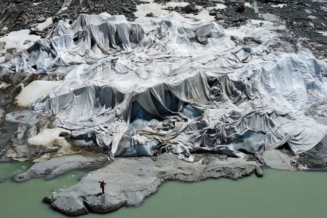 The Rhone Glacier near Goms, Switzerland, is partially covered with sheets as Matthias Huss, head of the Swiss glacier monitoring group Glamos, stands nearby