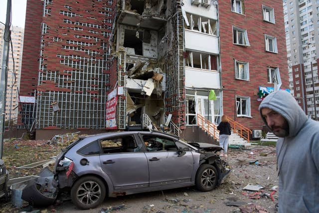 Residents react near their damaged multi-storey