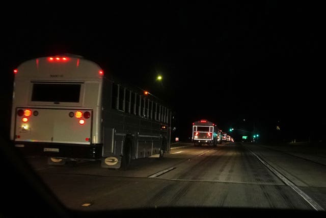A convoy of buses moves along Interstate Highway 10 after leaving the Marine Corps base in Twentynine Palms