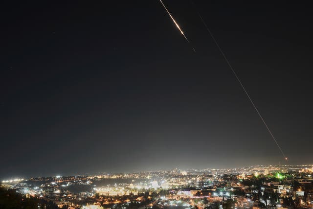 Projectiles break up in the night sky over Jerusalem during an Iranian missile attack on Friday