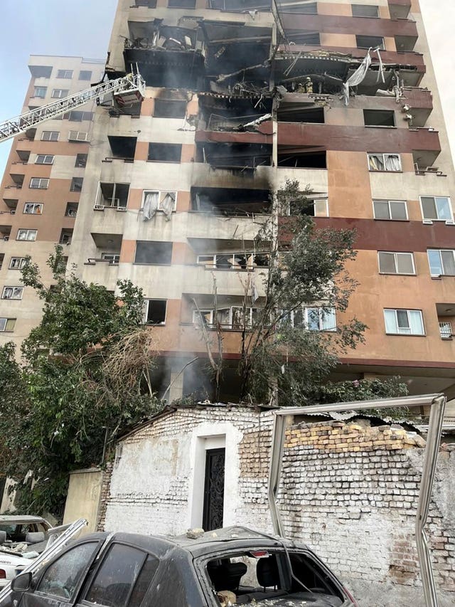 Firemen at a destroyed block of flats in Tehran