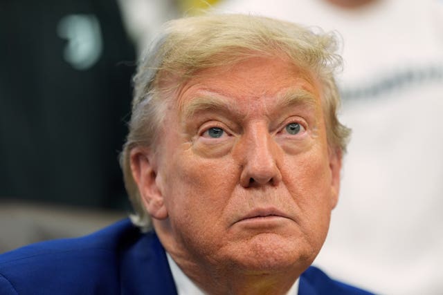 US President Donald Trump talks with reporters in the Oval Office of the White House in Washington