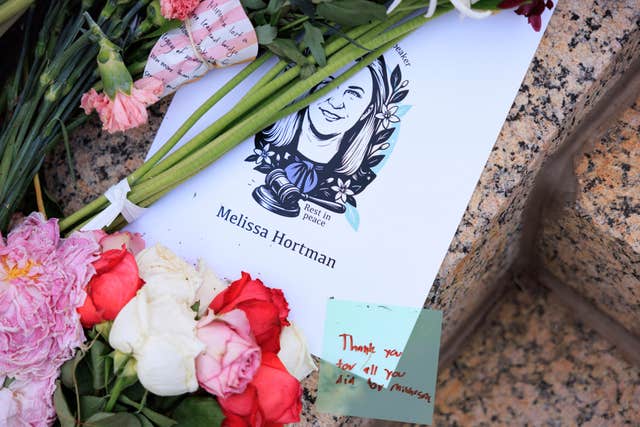 Flowers are laid at a vigil for Melissa Hortman