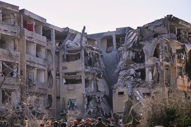 Israeli security forces inspect a destroyed building in Holon, near Tel Aviv, that was hit by a missile