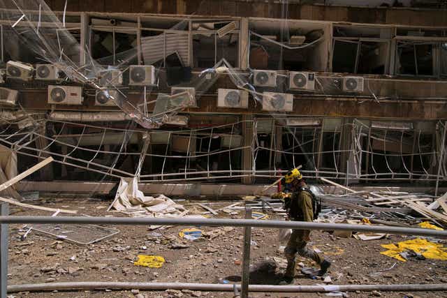 A firefighter walks past a damaged area at the Soroka hospital complex after it was hit by a missile fired from Iran in Be’er Sheva, Israel
