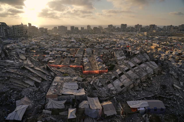 A tent camp for displaced Palestinians stretches among the ruins of buildings destroyed by Israeli bombardments