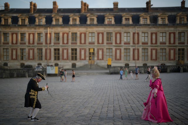 Costumed guests take photos as they arrive at the Great Masked Ball