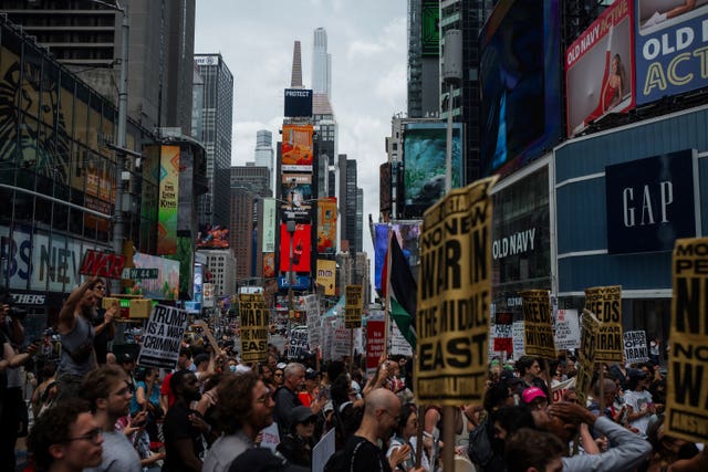 Protesters carry signs during a protest in New York on Sunday against US strikes on Iran