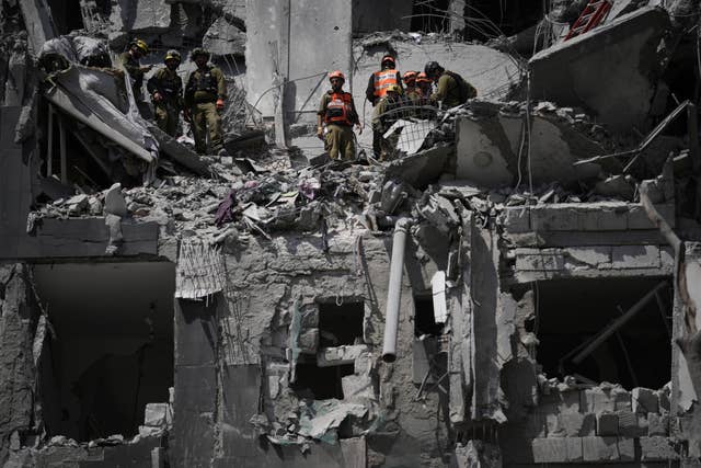Israeli soldiers working at the site struck by an Iranian missile strike
