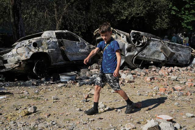 Damaged cars lie in a yard among other debris after a Russian drone and missile attacks