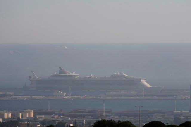 A cruise ship seen through the smoke in the port of Marseille