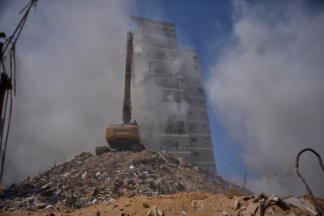 Construction vehicles demolish a building that was struck by an Iranian missile during the 12-day Israel-Iran war last month, in Bat Yam, Israel