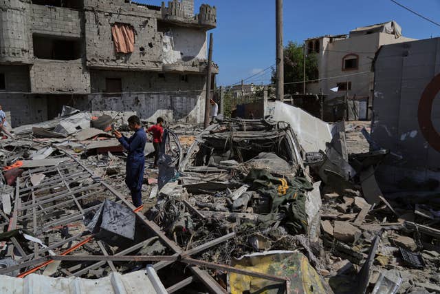 People inspect the wreckage of a petrol station destroyed in an Israeli airstrike