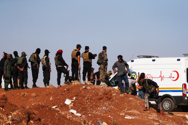 A convoy of ambulances and buses arrives at a checkpoint in a village in southern Syria on its way to Sweida