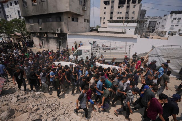 Palestinians carry the bodies of people who were killed in an Israeli airstrike