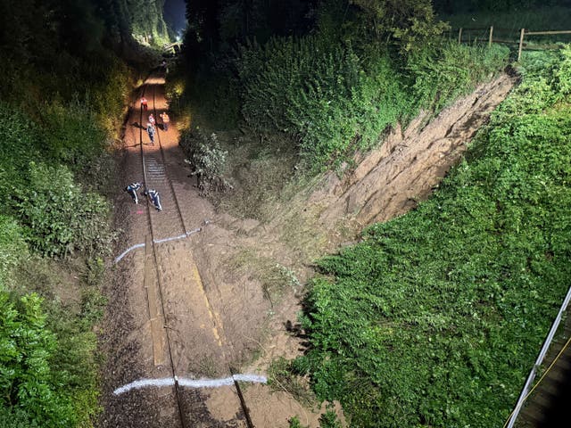 Emergency services work on the tracks by a landslide after a regional passenger train derailed near Riedlingen, Germany