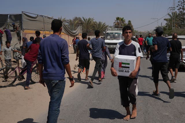 Palestinians collect humanitarian aid packages from the United Arab Emirates after they were airdropped into Zawaida, in the central Gaza Strip