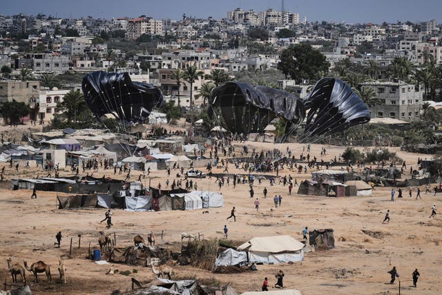 Palestinians rush to collect humanitarian aid airdropped into Zawaida in the central Gaza Strip