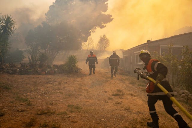 Firefighters battling a wildfire in a Mediterranean region near the Spanish border, southern France
