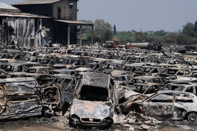 Burned cars are seen at an impound lot in Kato Achaia, during a wildfire near Patras city, western Greece