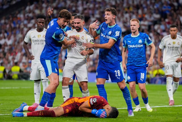 Marseille goalkeeper Geronimo Rulli lies on the ground after apparently being headbutted by Real Madrid's Dani Carvajal