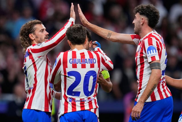Atletico Madrid’s Antoine Griezmann claps hands with Matteo Ruggeri over the head of team-mate Giuliano Simeone