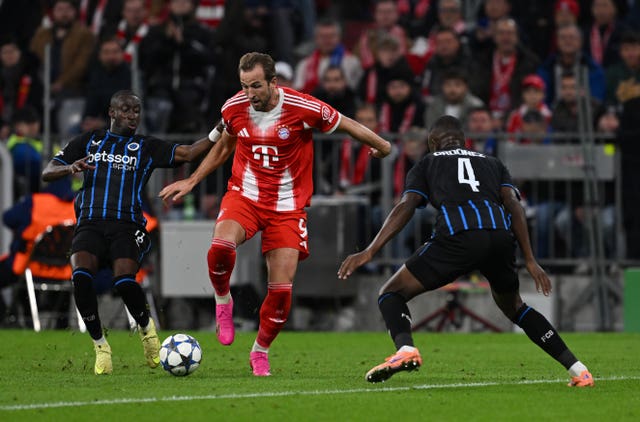 Club Brugge’s Carlos Forbs, left, and Joel Ordonez challenge Bayern Munich’s Harry Kane