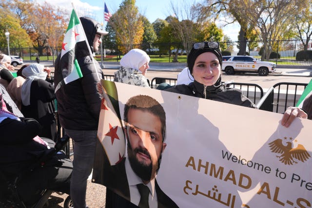 Peopl holding banners near the White House in support of Syria’s President Ahmed al-Sharaa