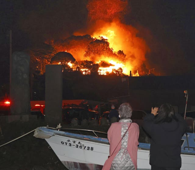 Residents watch flames rise from the fire in Oita, southern Japan